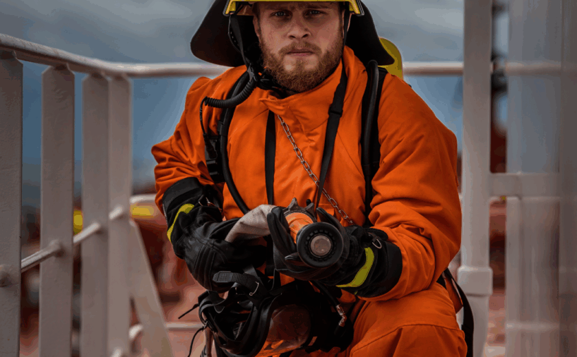 Marine firefighter in full protective suit during onboard fire drill under SOLAS Chapter II-2 and IMO MSC.1/Circ.1432, performed by OJ Safety engineers in European waters.
