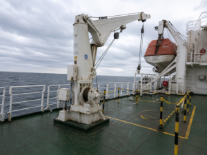 Davit test setup on ship deck with safety barriers isolated zone for load test MSC 402 inspection lifeboat davit system